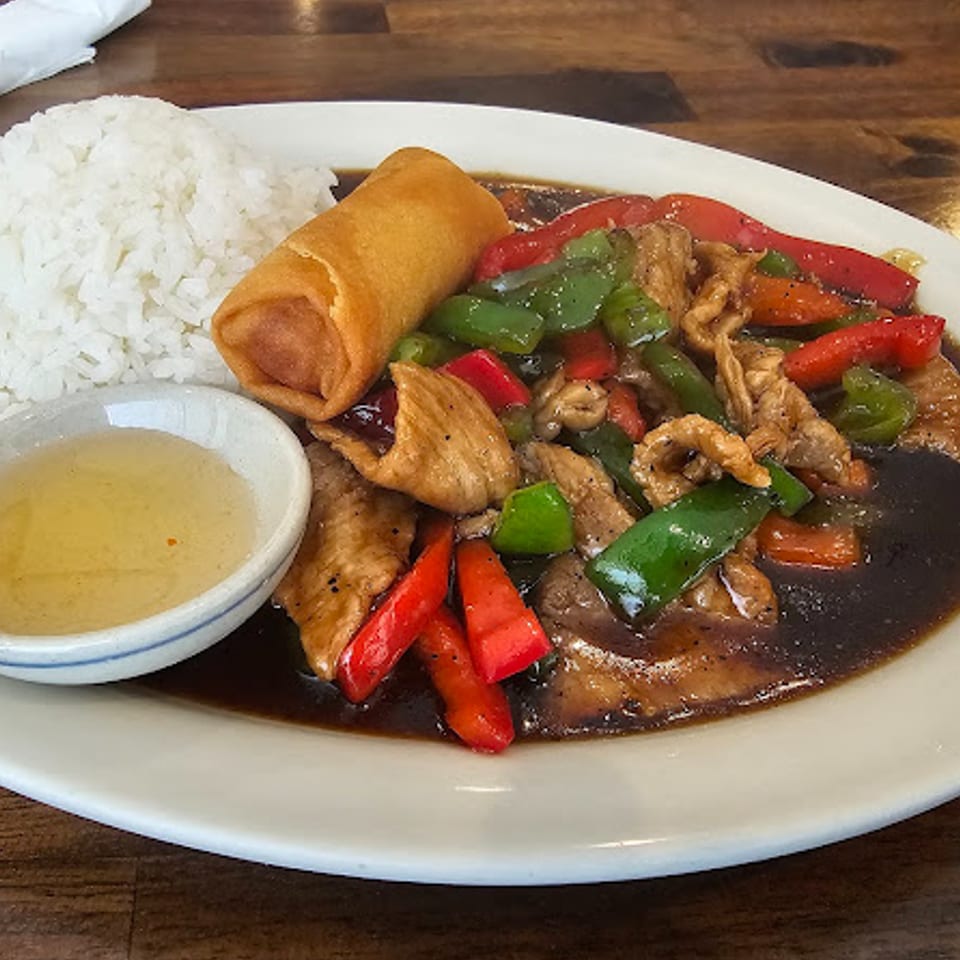 Thai Chili Asian Bistro's chicken stir-fry with bell peppers, rice, egg roll, and dipping sauce.